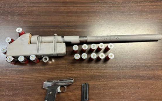 A man accused of making terroristic threats had a loaded, stolen pistol and loaded homemade shotgun near his feet, police say. (Courtesy Kalamazoo Department of Public Safety)